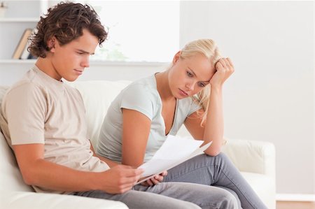 simsearch:400-05746763,k - Worried couple reading letters in the living room Stock Photo - Budget Royalty-Free & Subscription, Code: 400-04904952
