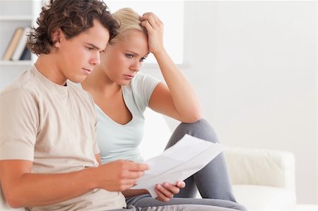 simsearch:400-05746763,k - Despaired couple reading letters in the living room Stock Photo - Budget Royalty-Free & Subscription, Code: 400-04904953