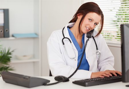 doctor business computer - A female doctor is telephoning and typing in an office Stock Photo - Budget Royalty-Free & Subscription, Code: 400-04905048