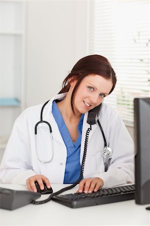 doctor business computer - A female doctor is working with her pc and telephoning in her office Stock Photo - Budget Royalty-Free & Subscription, Code: 400-04905054