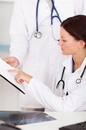 simsearch:400-04552598,k - A female doctor is pointing on something on a file Foto de stock - Super Valor sin royalties y Suscripción, Código: 400-04905099