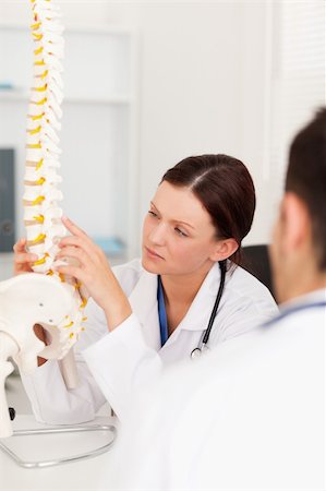 patient talking to office worker - A female doctor is touching a spine in office Stock Photo - Budget Royalty-Free & Subscription, Code: 400-04905101