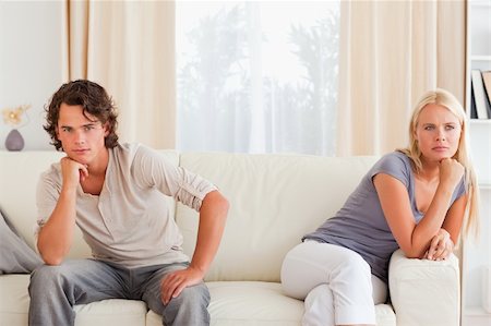 simsearch:400-05350485,k - Upset couple sitting on a sofa with their hand on their chin Photographie de stock - Aubaine LD & Abonnement, Code: 400-04905451