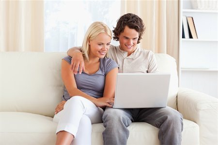 Friendly couple using a notebook in their living room Stock Photo - Budget Royalty-Free & Subscription, Code: 400-04905531