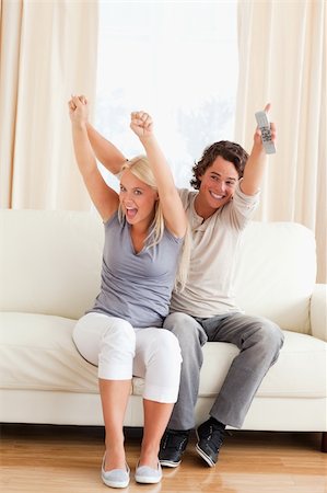 elegant tv room - Portrait of a young couple cheering up while watching TV Stock Photo - Budget Royalty-Free & Subscription, Code: 400-04905564