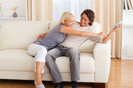 elegant tv room - Smiling couple fighting for the remote in their living room Stock Photo - Budget Royalty-Free & Subscription, Code: 400-04905561