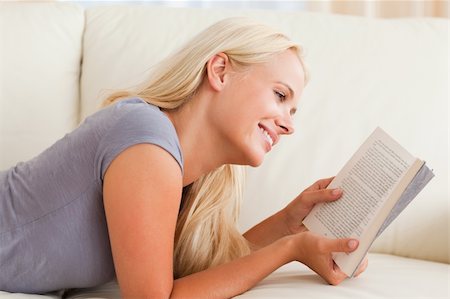 simsearch:400-04905604,k - Smiling woman reading a book in her living room Stockbilder - Microstock & Abonnement, Bildnummer: 400-04905602