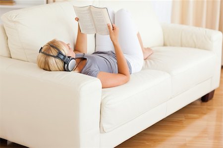 Woman listenning to music while reading a book in her living room Stock Photo - Budget Royalty-Free & Subscription, Code: 400-04905833