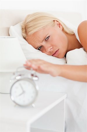 simsearch:6109-06194402,k - Portrait of a cute woman awaken by an alarmclock in her bedroom Stock Photo - Budget Royalty-Free & Subscription, Code: 400-04905999