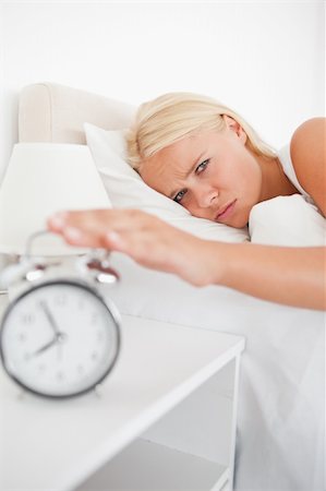 simsearch:6109-06194402,k - Portrait of a tired woman awaken by an alarmclock in her bedroom Stock Photo - Budget Royalty-Free & Subscription, Code: 400-04906005
