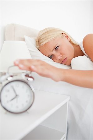 simsearch:6109-06194402,k - Portrait of an unhappy woman awaken by an alarmclock in her bedroom Stock Photo - Budget Royalty-Free & Subscription, Code: 400-04906008