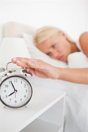 simsearch:6109-06194402,k - Portrait of an unhappy woman switching off her alarmclock in her bedroom Stock Photo - Budget Royalty-Free & Subscription, Code: 400-04906009
