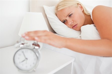 simsearch:6109-06194408,k - Unhappy woman awaken by an alarmclock in her bedroom Stockbilder - Microstock & Abonnement, Bildnummer: 400-04906000