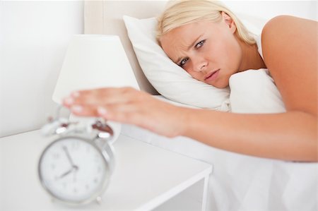 simsearch:6109-06194408,k - Tired woman awaken by an alarmclock in her bedroom Stockbilder - Microstock & Abonnement, Bildnummer: 400-04906002