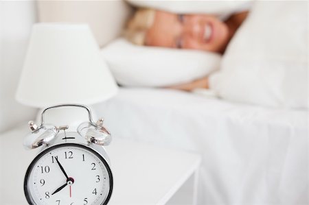 simsearch:6109-06194402,k - Woman hidding her head in a pillow while the alarrmclock is ringing in her bedroom Stock Photo - Budget Royalty-Free & Subscription, Code: 400-04906016