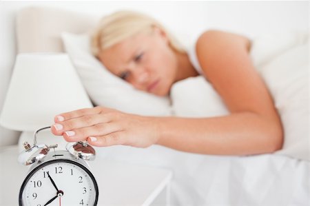 simsearch:6109-06194402,k - Woman switching off her alarm clock in her bedroom Stock Photo - Budget Royalty-Free & Subscription, Code: 400-04906010
