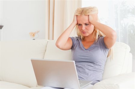 sad woman sitting alone on couch - Unhappy woman with a laptop in her living room Stock Photo - Budget Royalty-Free & Subscription, Code: 400-04906024