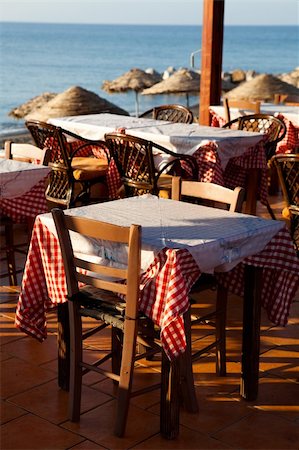 Outdoor restaurant tables by the beach in Perissa, Santorini, Greece Stock Photo - Budget Royalty-Free & Subscription, Code: 400-04906997