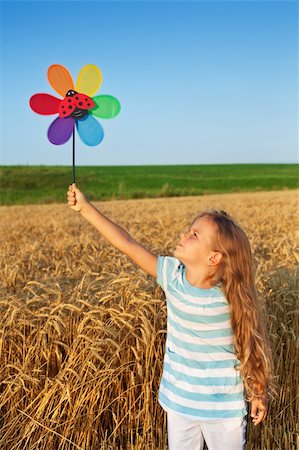 Little girl playing outdoors in summer time with a windmill toy Stock Photo - Budget Royalty-Free & Subscription, Code: 400-04907053
