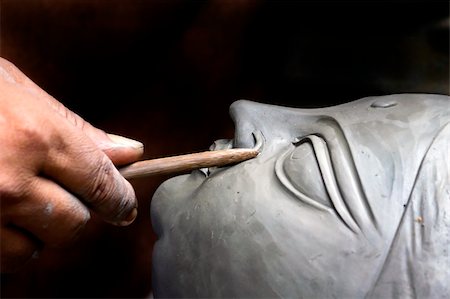 scultore (uomo e donna) - An artisan creates the head of a goddess for Durga puja festival in kolkata, India Fotografie stock - Microstock e Abbonamento, Codice: 400-04908147