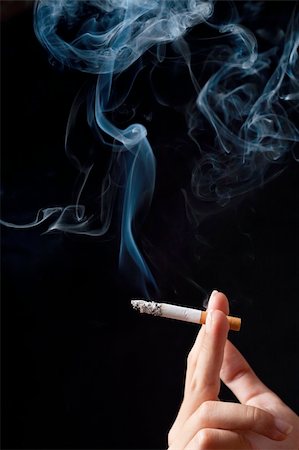 Hand with smoking cigaret. Isolated over black. Stock Photo - Budget Royalty-Free & Subscription, Code: 400-04908365