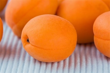 Ripe fresh apricot on blue background close-up shallow DOF Fotografie stock - Microstock e Abbonamento, Codice: 400-04909297