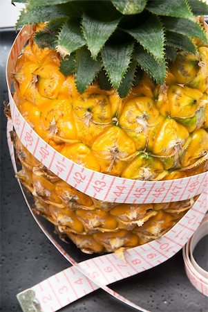 ripe vivid pineapple on a black plate with tape meter Stock Photo - Budget Royalty-Free & Subscription, Code: 400-04909612