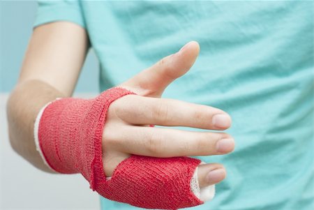 Injured male hand with upper part of body. Hand is bandaged with red plaster focus set on thumb Stock Photo - Budget Royalty-Free & Subscription, Code: 400-04900271