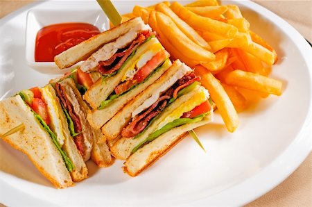 fresh triple decker club sandwich with french fries on side Photographie de stock - Aubaine LD & Abonnement, Code: 400-04901060