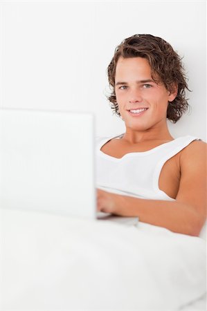 Man using a notebook in his bedroom Stock Photo - Budget Royalty-Free & Subscription, Code: 400-04903528