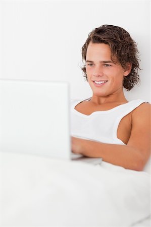 Portrait of a man using a laptop in his bedroom Stock Photo - Budget Royalty-Free & Subscription, Code: 400-04903529