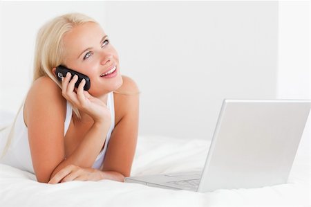 simsearch:400-05737165,k - Woman on the phone with a laptop in her bedroom Stock Photo - Budget Royalty-Free & Subscription, Code: 400-04903785