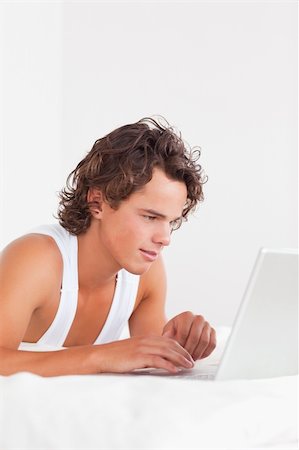 Portrait of a man using a laptop in his bedroom Stock Photo - Budget Royalty-Free & Subscription, Code: 400-04903845