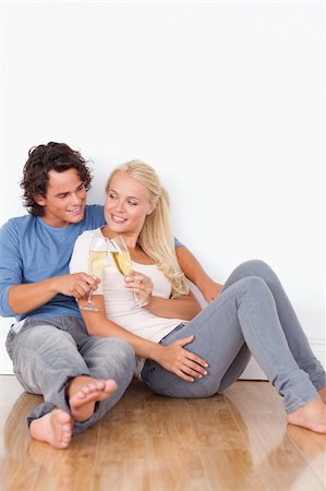 Portrait of a beautiful couple toasting while sitting on the floor Stock Photo - Budget Royalty-Free & Subscription, Code: 400-04903965