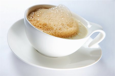 simsearch:400-06701416,k - A close-up of a white cup of hot coffee with froth over light background Stock Photo - Budget Royalty-Free & Subscription, Code: 400-04914132