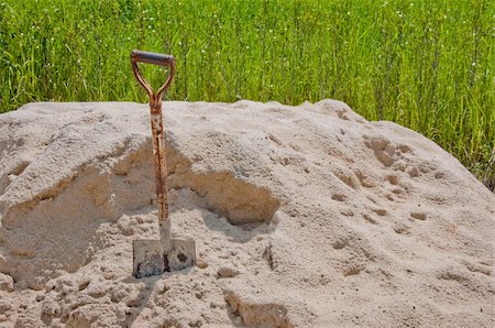 a picture of a shovel in sand with green grass background Foto de stock - Royalty-Free Super Valor e Assinatura, Número: 400-04914472