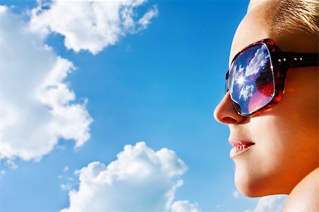 side lips view pictures - Closeup portrait of a young pretty woman with sunglasses watching the blue  sky with the sun and white clouds Stock Photo - Budget Royalty-Free & Subscription, Code: 400-04914969