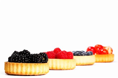 photos of blueberries for kitchen - blackberries and other wild berries in tartlet cakes on white background Foto de stock - Super Valor sin royalties y Suscripción, Código: 400-04916897