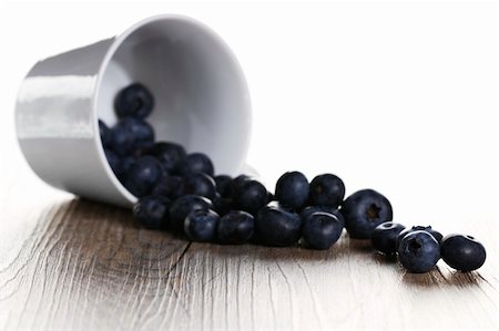 photos of blueberries for kitchen - blueberries rolling from a fell over cup with back light Foto de stock - Super Valor sin royalties y Suscripción, Código: 400-04916901