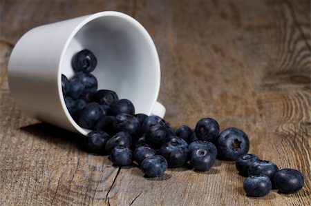 photos of blueberries for kitchen - blueberries rolling from a fell over cup on wooden background Stock Photo - Budget Royalty-Free & Subscription, Code: 400-04916903