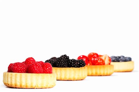 photos of blueberries for kitchen - raspberries in tartlet cake in front of other tartlet cakes with wild berries on white background Foto de stock - Super Valor sin royalties y Suscripción, Código: 400-04916945