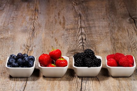 photos of blueberries for kitchen - row of wild berries in bowls on wooden background Stock Photo - Budget Royalty-Free & Subscription, Code: 400-04916948