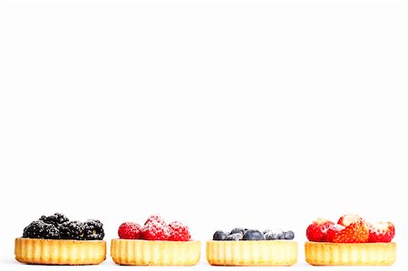 strawberry tartlet - row of tartlets with sugar covered wild berries on white background Stock Photo - Budget Royalty-Free & Subscription, Code: 400-04916949
