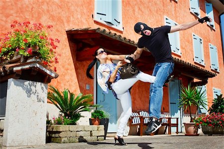 foot fight - Good looking pretty woman defending herself kicking a mugger between the legs who trying to steal her bag in the street Stock Photo - Budget Royalty-Free & Subscription, Code: 400-04917024