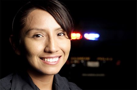 a smiling police officer with her patrol unit in the background with its lights on. Stock Photo - Budget Royalty-Free & Subscription, Code: 400-04917195