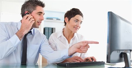 Businessman showing something to his coworker on a computer in an office Stock Photo - Budget Royalty-Free & Subscription, Code: 400-04917877