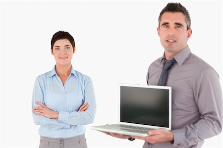 simsearch:400-04918393,k - Office worker showing a notebook while his colleague is posing against a white backgroung Stock Photo - Budget Royalty-Free & Subscription, Code: 400-04917918