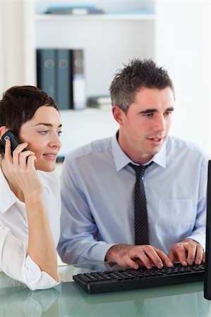 Portrait of a woman telephoning while her colleague is using a computer in an office Stock Photo - Budget Royalty-Free & Subscription, Code: 400-04917923