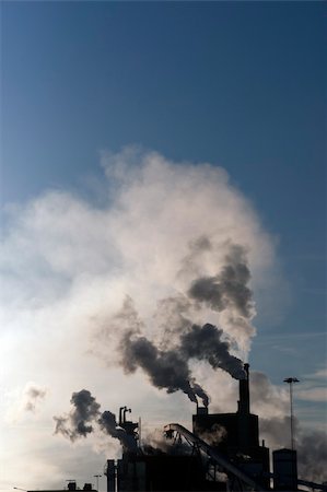 environmental issues petrochemicals - Factory with chimneys emmiting smoke on blue sky Stock Photo - Budget Royalty-Free & Subscription, Code: 400-04917936