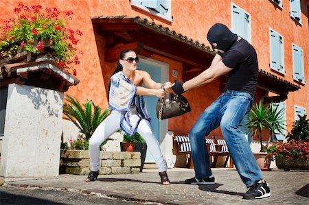 female foot kicks - Good looking pretty woman defending herself kicking a mugger between the legs who trying to steal her bag in the street Stock Photo - Budget Royalty-Free & Subscription, Code: 400-04918061